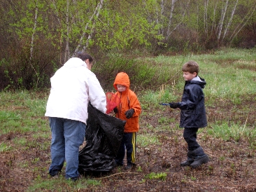 Young volunteers loading a trash bag